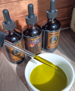 Phoebe's Cottage Garden Oil with dropper showing green herbal-infused oil